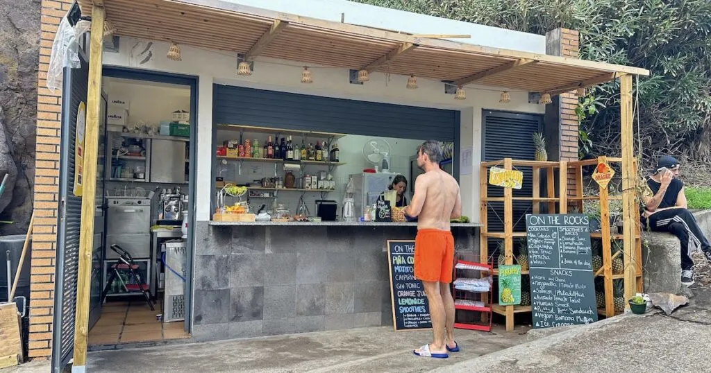 A man waits at a small, colourful snack bar next to the Seixal swimming pools.