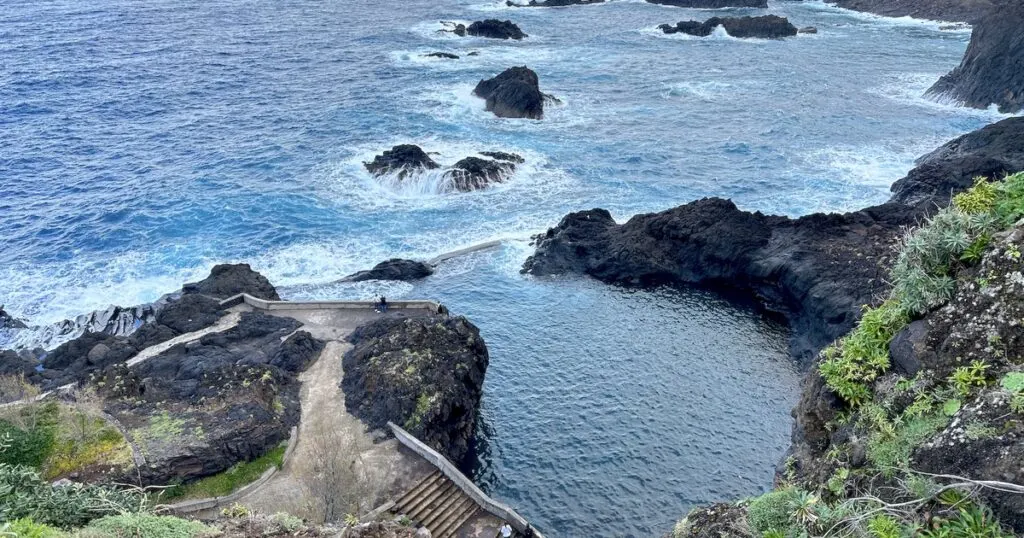 View over a natural pool separated from the Atlantic sea by a wall.